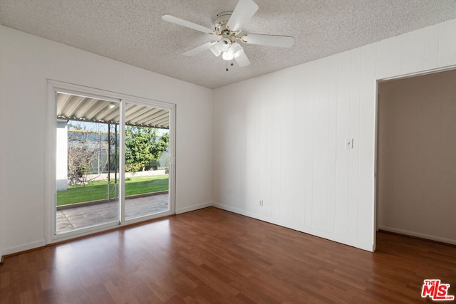 unfurnished room with ceiling fan, dark hardwood / wood-style floors, and a textured ceiling