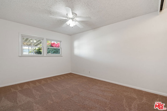 empty room featuring ceiling fan, carpet, and a textured ceiling