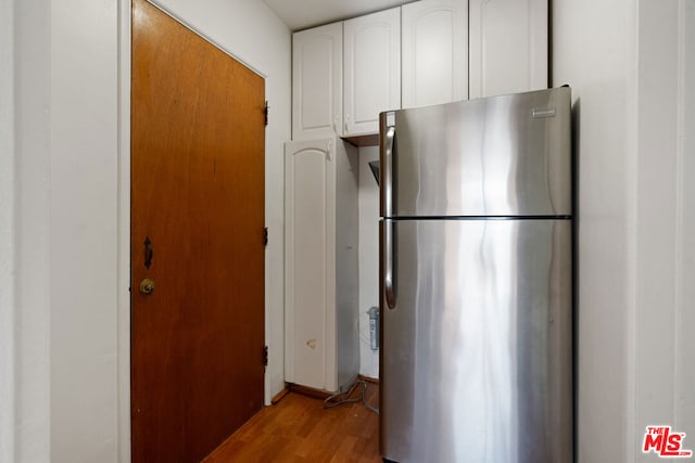 kitchen featuring white cabinetry, light wood-type flooring, and stainless steel refrigerator