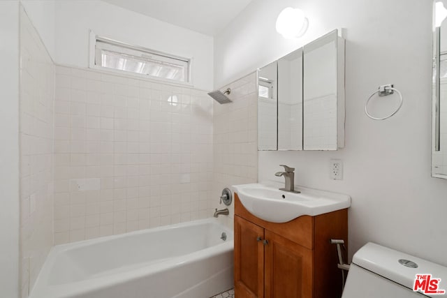 full bathroom with vanity, tiled shower / bath combo, and toilet