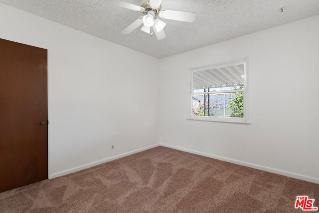 carpeted spare room featuring ceiling fan and a textured ceiling