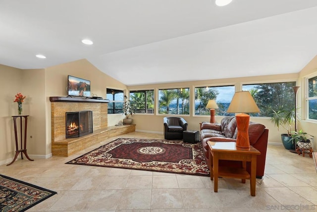 living room featuring a tiled fireplace, light tile patterned flooring, and lofted ceiling