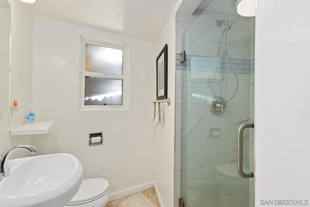 bathroom featuring an enclosed shower, sink, and toilet