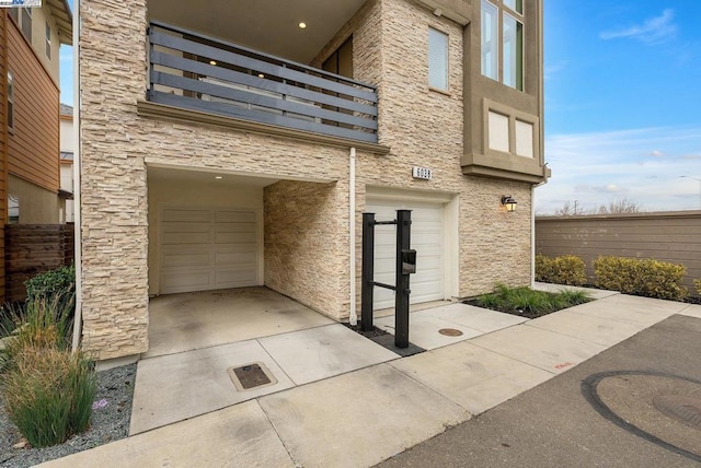 property entrance featuring a balcony and a garage