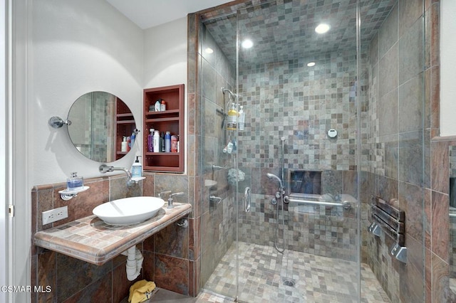 bathroom with a shower with door and sink