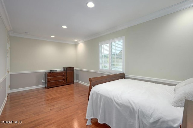 bedroom featuring ornamental molding and light wood-type flooring