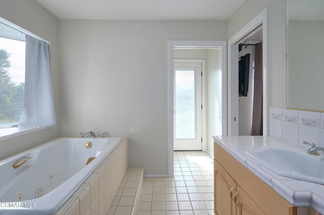 bathroom with backsplash, vanity, tile patterned flooring, and tiled tub