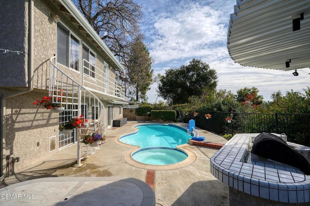 view of pool with an in ground hot tub and a patio