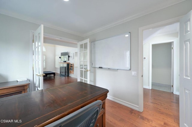 unfurnished office featuring wood-type flooring, ornamental molding, and french doors