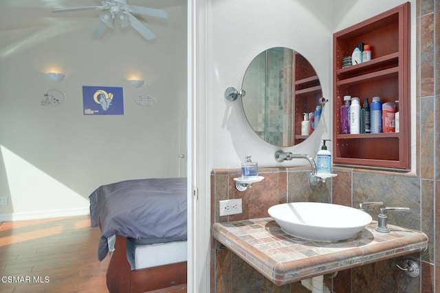 bathroom featuring tasteful backsplash, sink, hardwood / wood-style floors, and ceiling fan