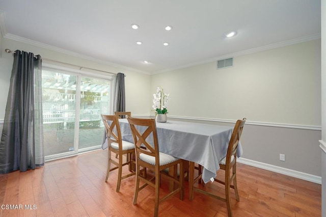 dining room featuring ornamental molding and light wood-type flooring