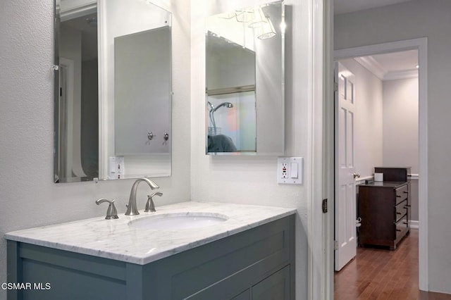 bathroom with vanity, ornamental molding, and hardwood / wood-style floors