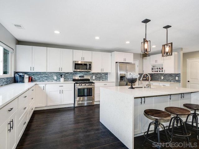 kitchen with stainless steel appliances, white cabinetry, and sink