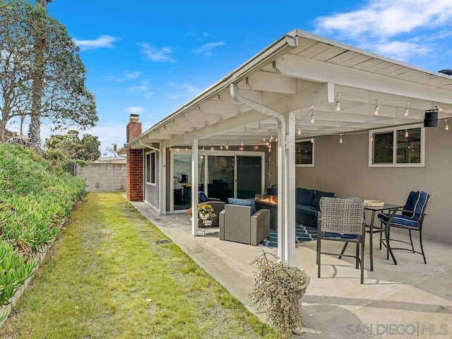 rear view of house with an outdoor living space, a lawn, and a patio