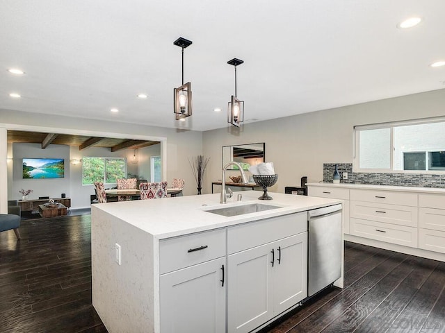 kitchen with sink, decorative light fixtures, stainless steel dishwasher, a kitchen island with sink, and white cabinets