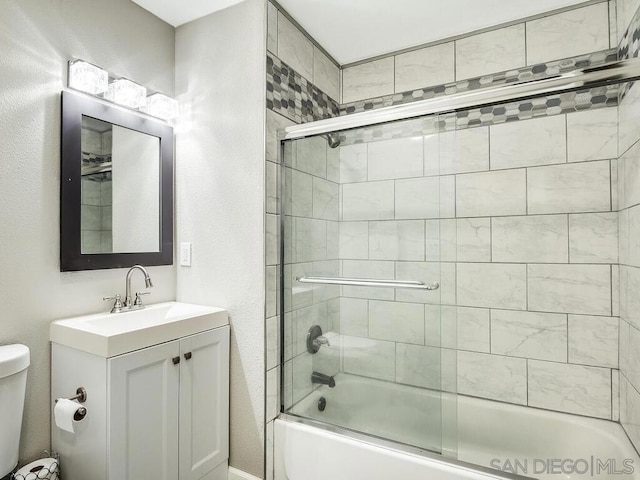 full bathroom featuring toilet, vanity, and shower / bath combination with glass door