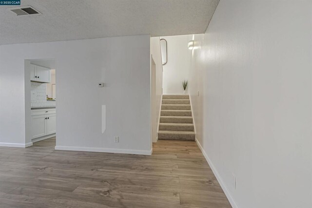 interior space featuring wood-type flooring and a textured ceiling