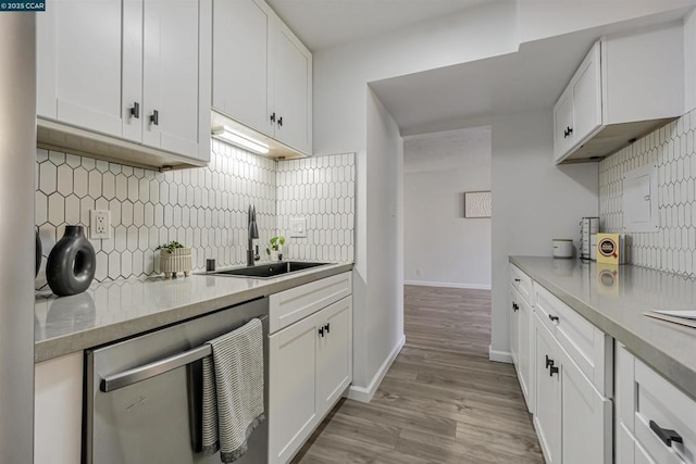 kitchen with white cabinetry, dishwasher, and sink