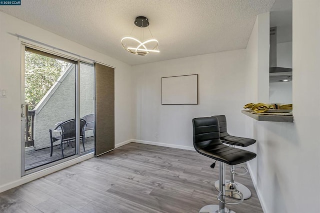 interior space featuring wood-type flooring, a notable chandelier, and a textured ceiling