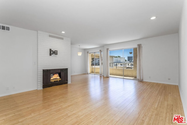 unfurnished living room featuring a fireplace and light hardwood / wood-style floors