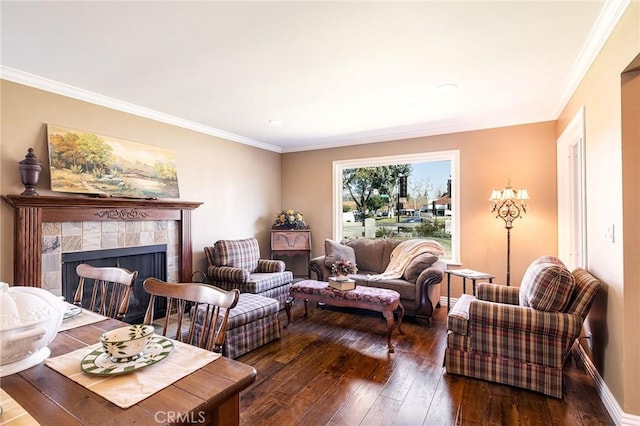 living room with a tile fireplace, dark wood-type flooring, and crown molding