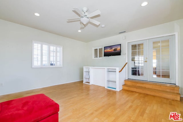 living area featuring hardwood / wood-style floors, ceiling fan, and french doors