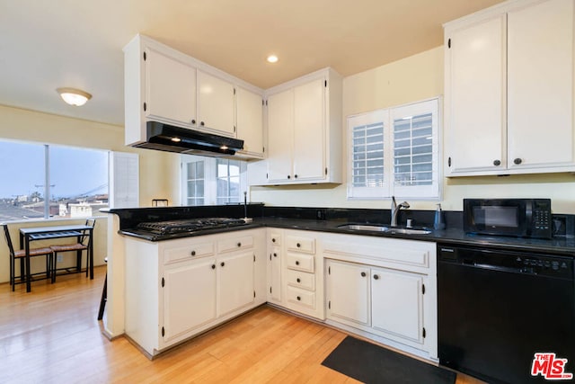 kitchen featuring sink, black appliances, and white cabinets