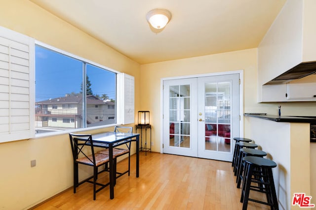 dining room featuring french doors and light wood-type flooring