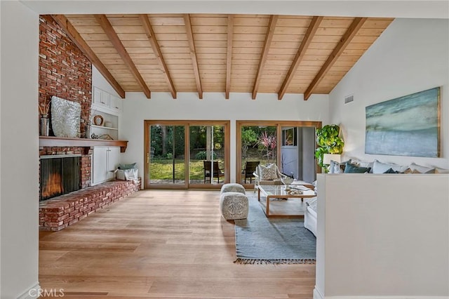 living room featuring beam ceiling, a brick fireplace, wooden ceiling, and light hardwood / wood-style floors