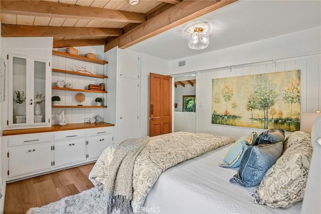 bedroom featuring wood ceiling, light wood-type flooring, and vaulted ceiling with beams