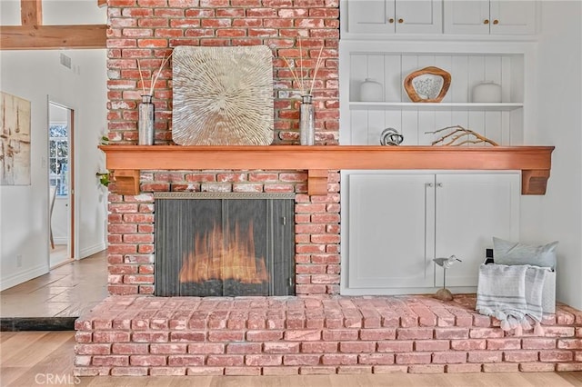 room details featuring built in shelves, a fireplace, and hardwood / wood-style flooring