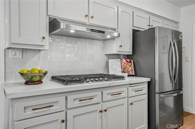 kitchen featuring light stone counters, decorative backsplash, light hardwood / wood-style flooring, and stainless steel appliances