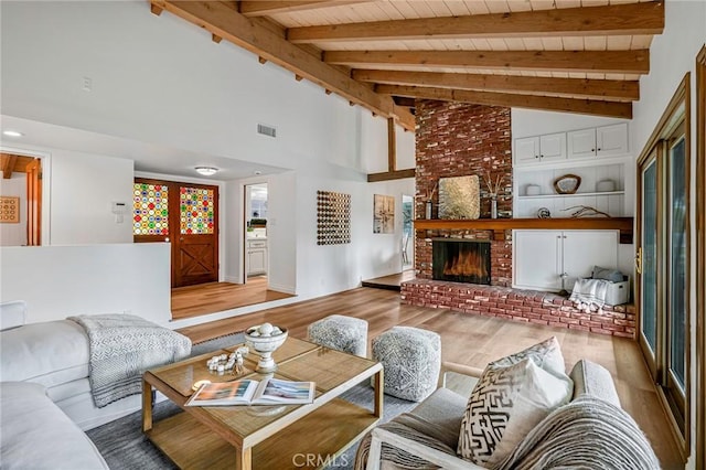 living room with a fireplace, light hardwood / wood-style floors, lofted ceiling with beams, and wooden ceiling