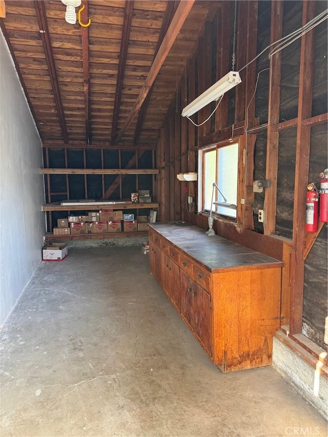 miscellaneous room featuring concrete flooring and vaulted ceiling