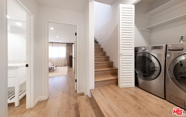 laundry area featuring separate washer and dryer and light hardwood / wood-style floors