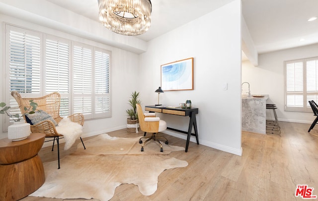 office area featuring a notable chandelier and light wood-type flooring