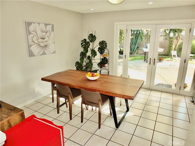 dining space with light tile patterned flooring and french doors