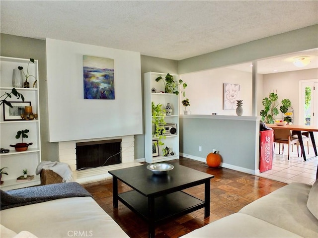 tiled living room with a textured ceiling and a fireplace