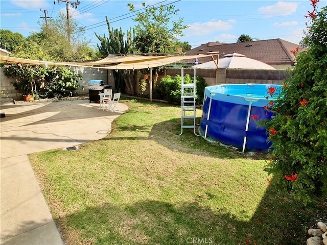 view of yard featuring a fenced in pool and a patio area