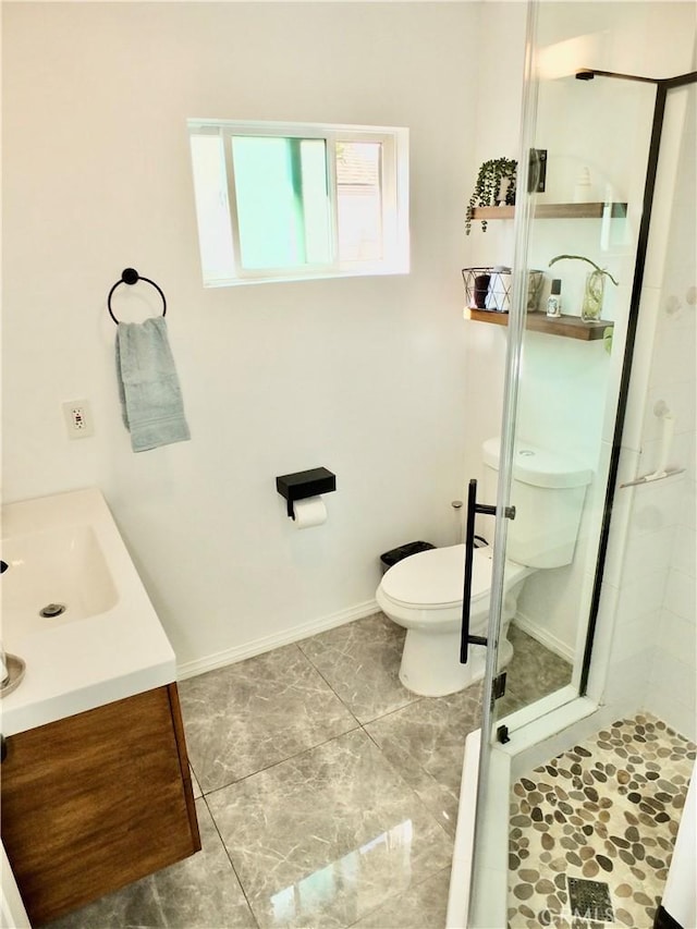 bathroom featuring a shower with door, vanity, and toilet