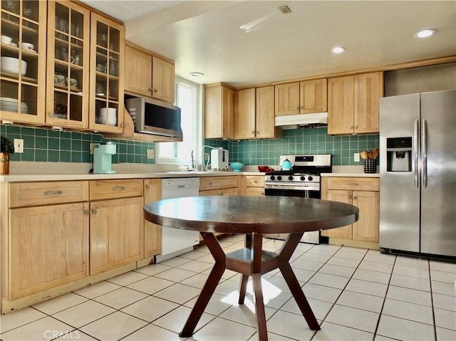 kitchen featuring stainless steel appliances, light tile patterned floors, and light brown cabinetry