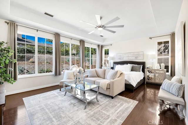 bedroom featuring dark wood-type flooring, ceiling fan, and a tray ceiling