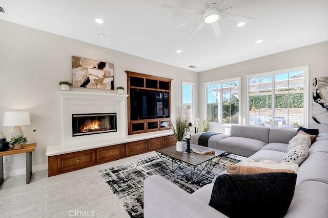 living room with plenty of natural light, ceiling fan, and light tile patterned flooring