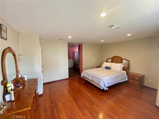 bedroom with dark wood-type flooring and a textured ceiling