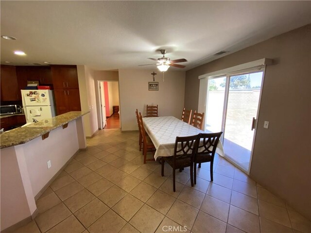 tiled dining area featuring ceiling fan