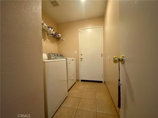 laundry area featuring washing machine and clothes dryer and light tile patterned floors