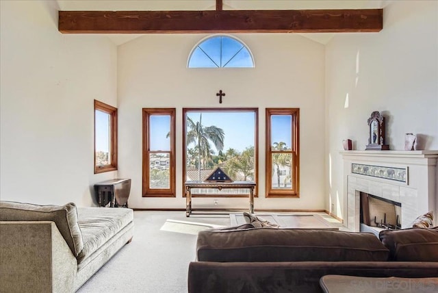 living room featuring a tiled fireplace, lofted ceiling with beams, and carpet flooring