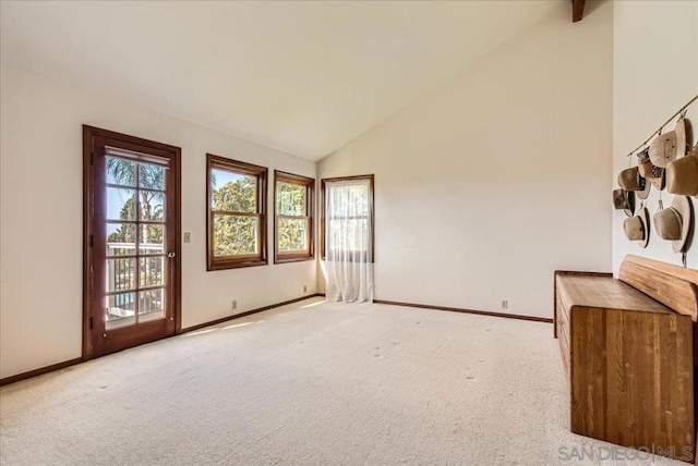 unfurnished living room with light colored carpet and high vaulted ceiling