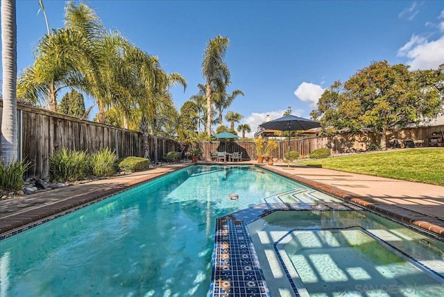 view of pool featuring an in ground hot tub and a yard