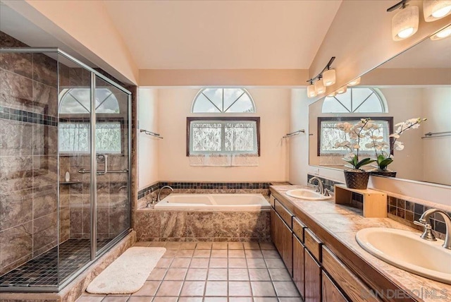 bathroom with tile patterned flooring, shower with separate bathtub, lofted ceiling, and vanity